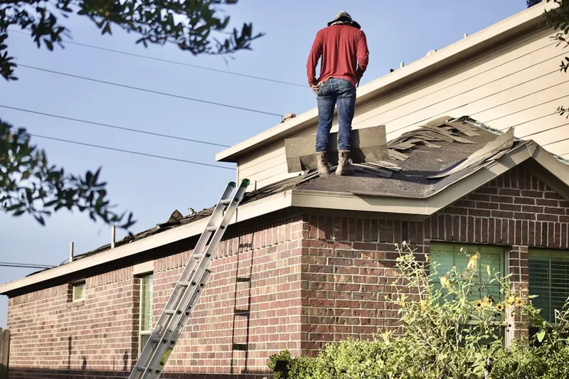 Professional roofer working on a residential roof in Farnham